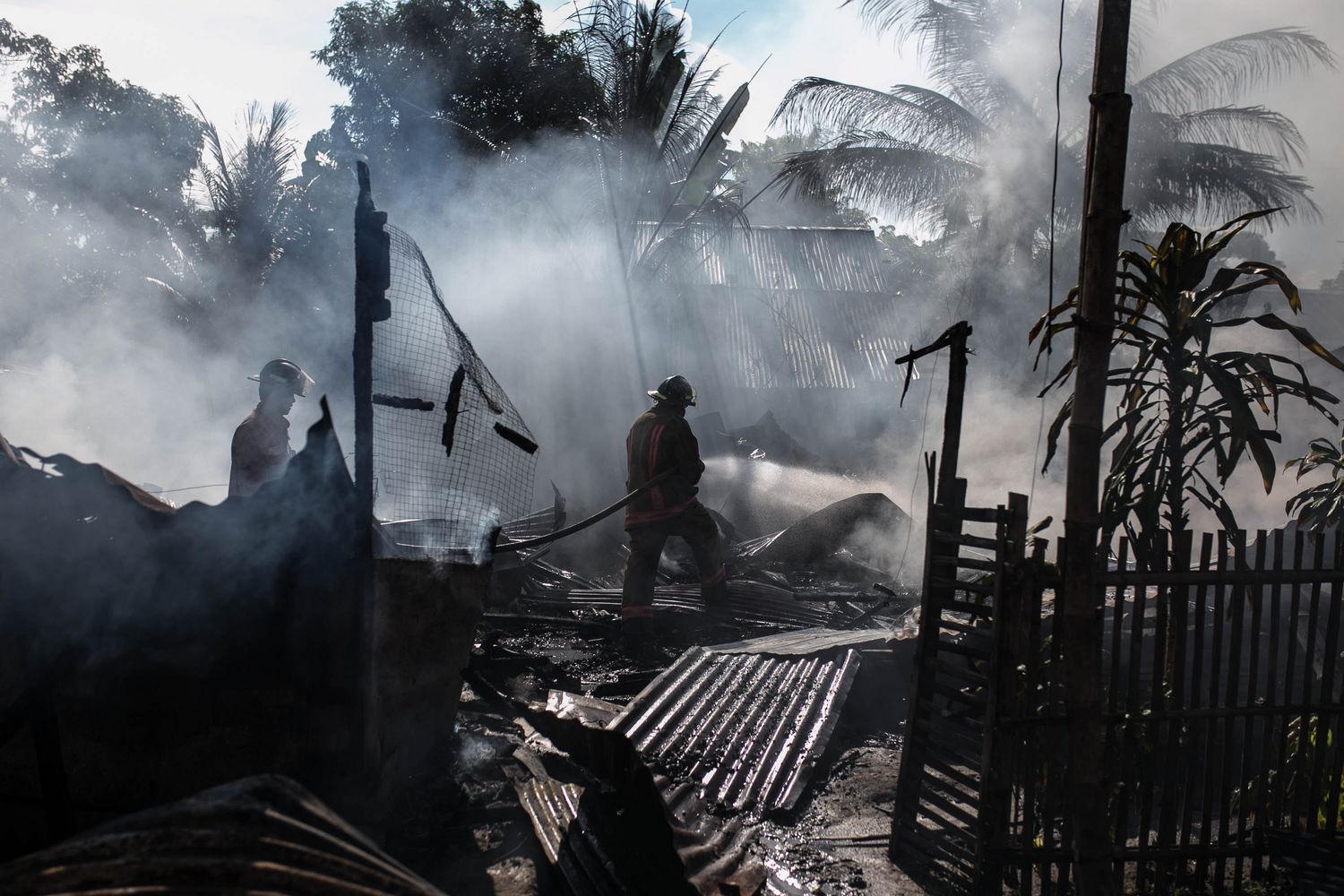 Pompiers dans un paysage tropical incendié