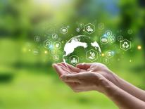 personne avec planète dans les mains et pictogrammes environnementaux