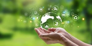 personne avec planète dans les mains et pictogrammes environnementaux